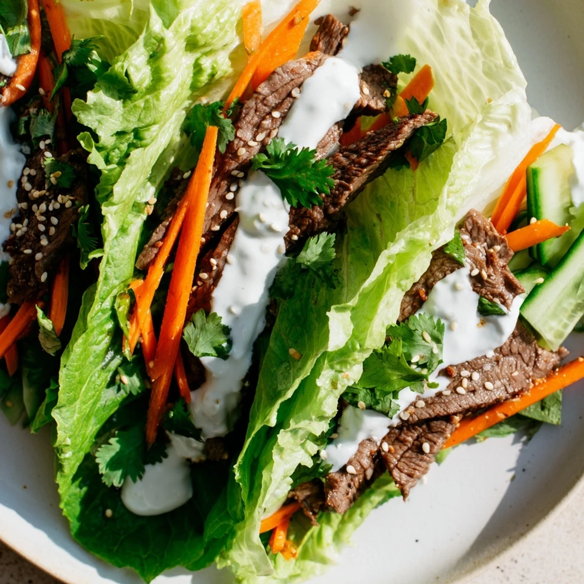 Close-up of a hand holding a nutritious Beef Wrap with Lettuce, showcasing creamy sauce and fresh herbs.