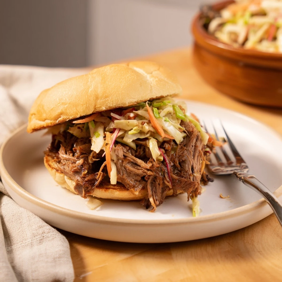 Tender Slow Cooker Pulled Beef Sandwiches piled high on soft brioche buns with creamy, tangy slaw.