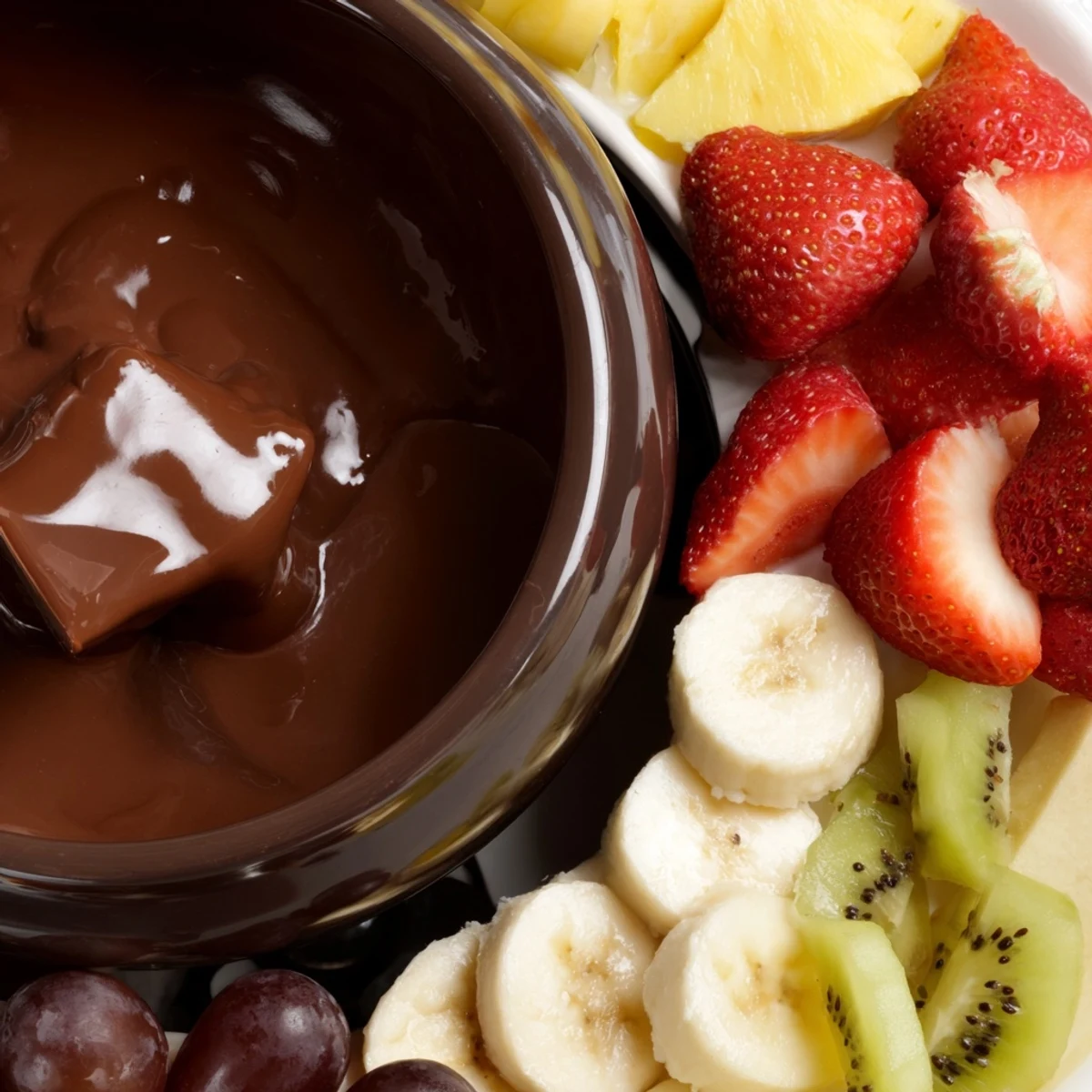 A warm, silky Valentine Chocolate Fondue with fresh fruit dipper platter, featuring ripe strawberries, bananas, and pineapple chunks.