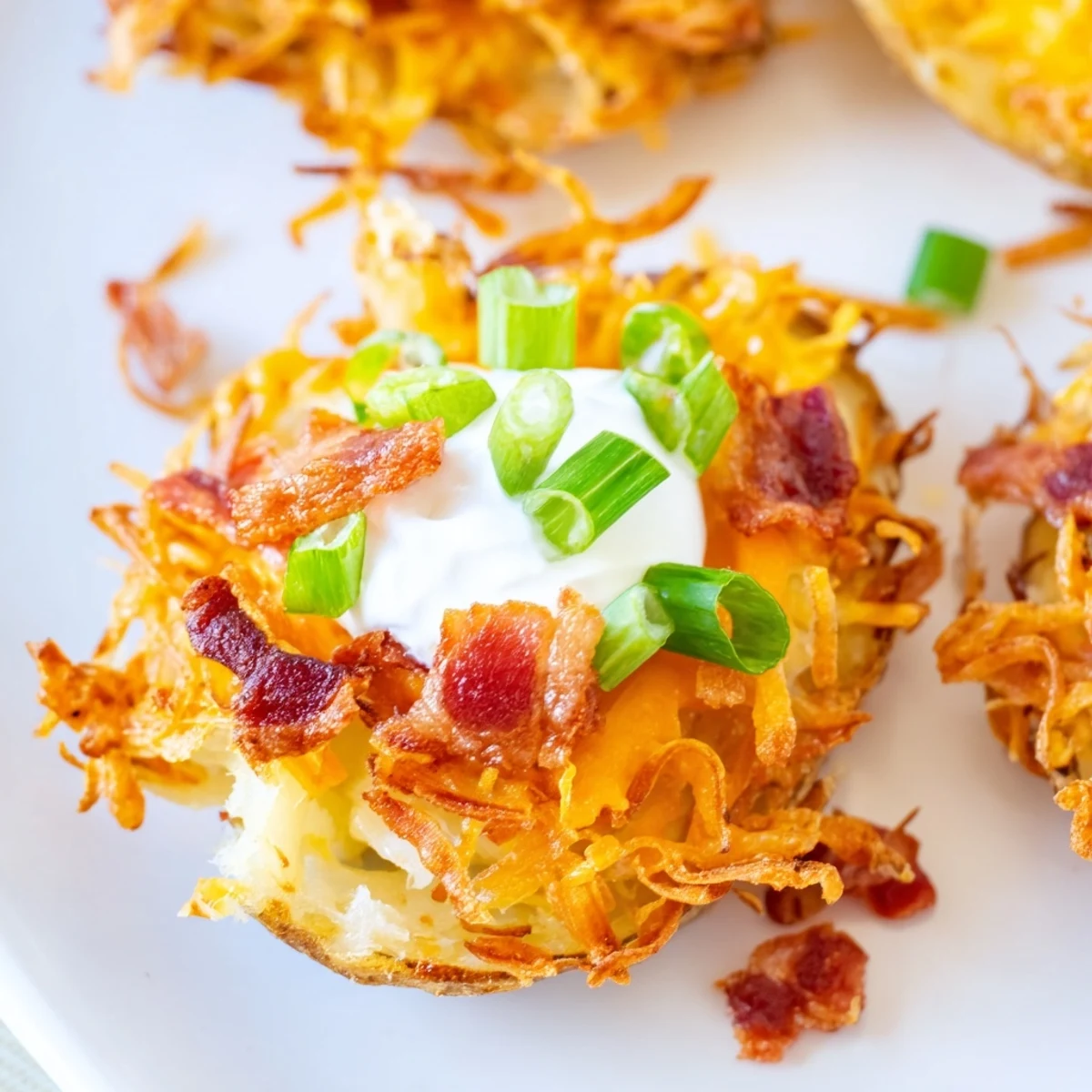 Two warm Game Day Loaded Potato Skins topped with sour cream and chives, perfect for a game day snack.