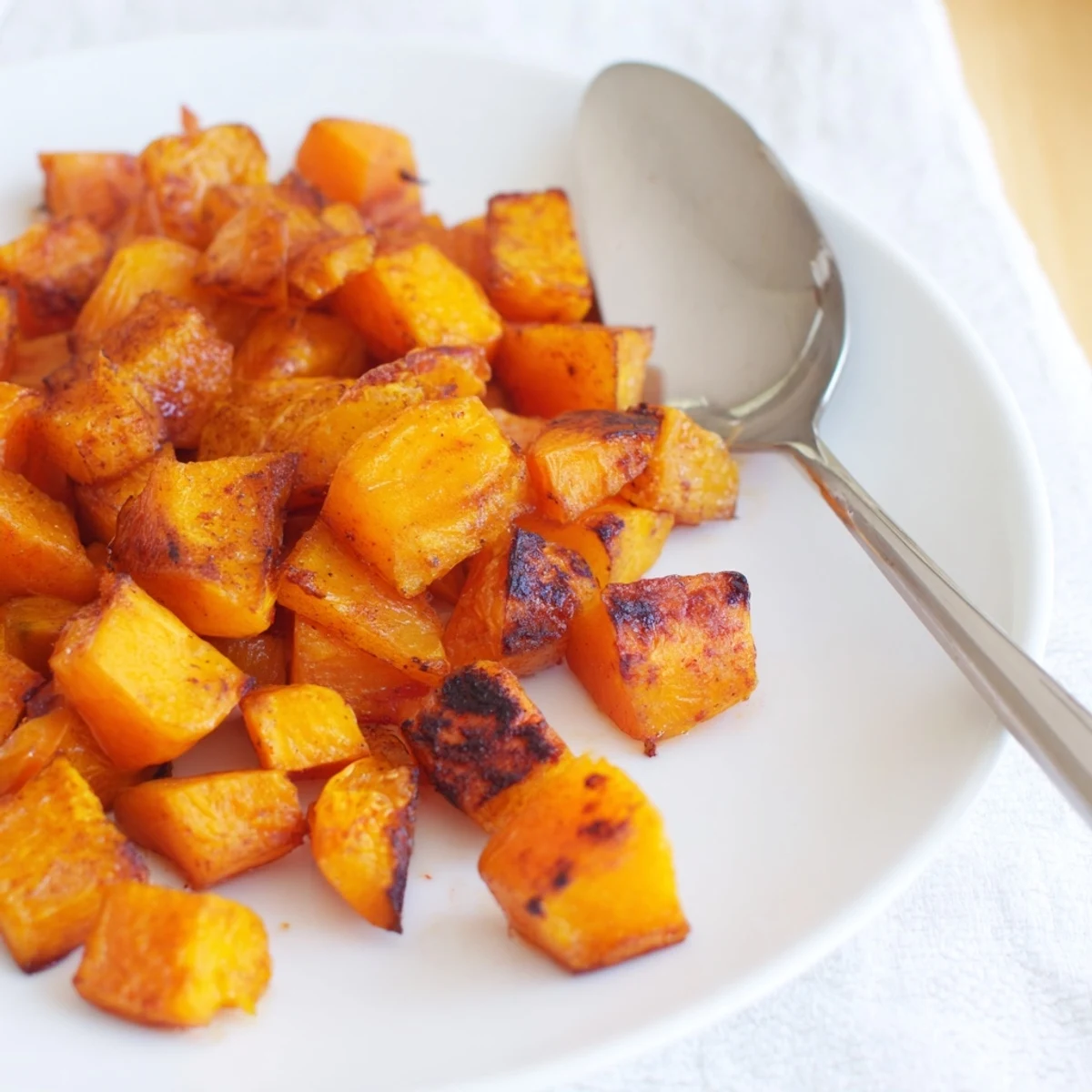 A close-up of tender roasted butternut squash seasoned with cinnamon, perfect as a comforting American side dish.  