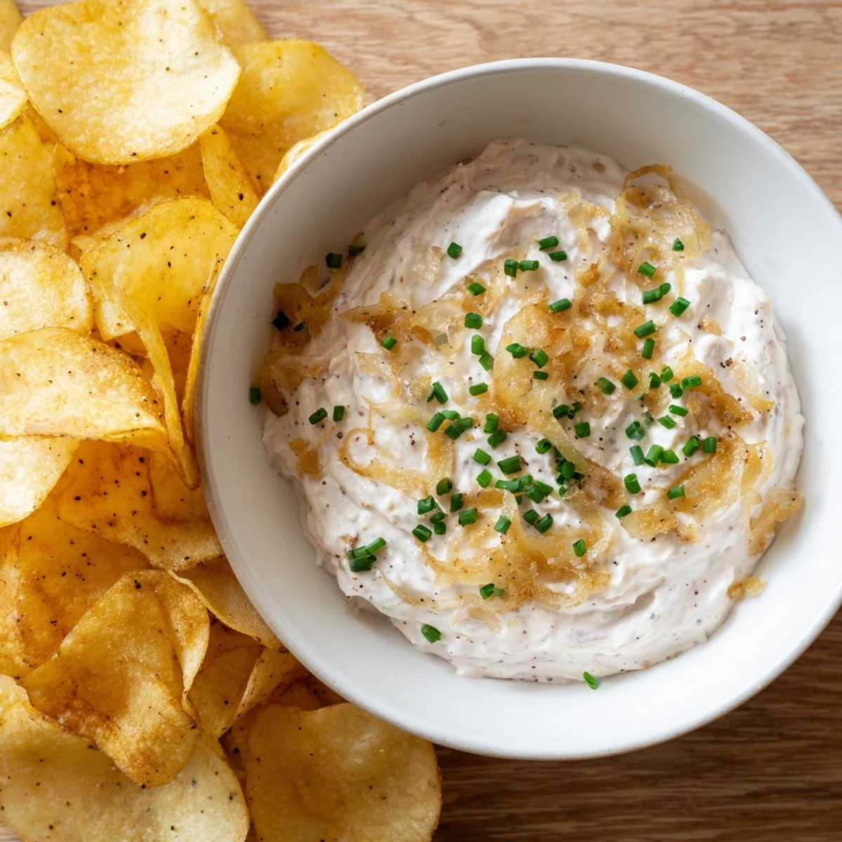 Golden caramelized onions blended into a creamy onion dip, served with crispy, salted potato chips for dipping.