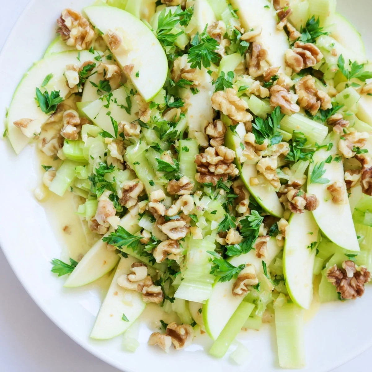A close-up of Apple and Celery Salad with Walnuts highlights crunchy textures and vibrant green parsley garnish.