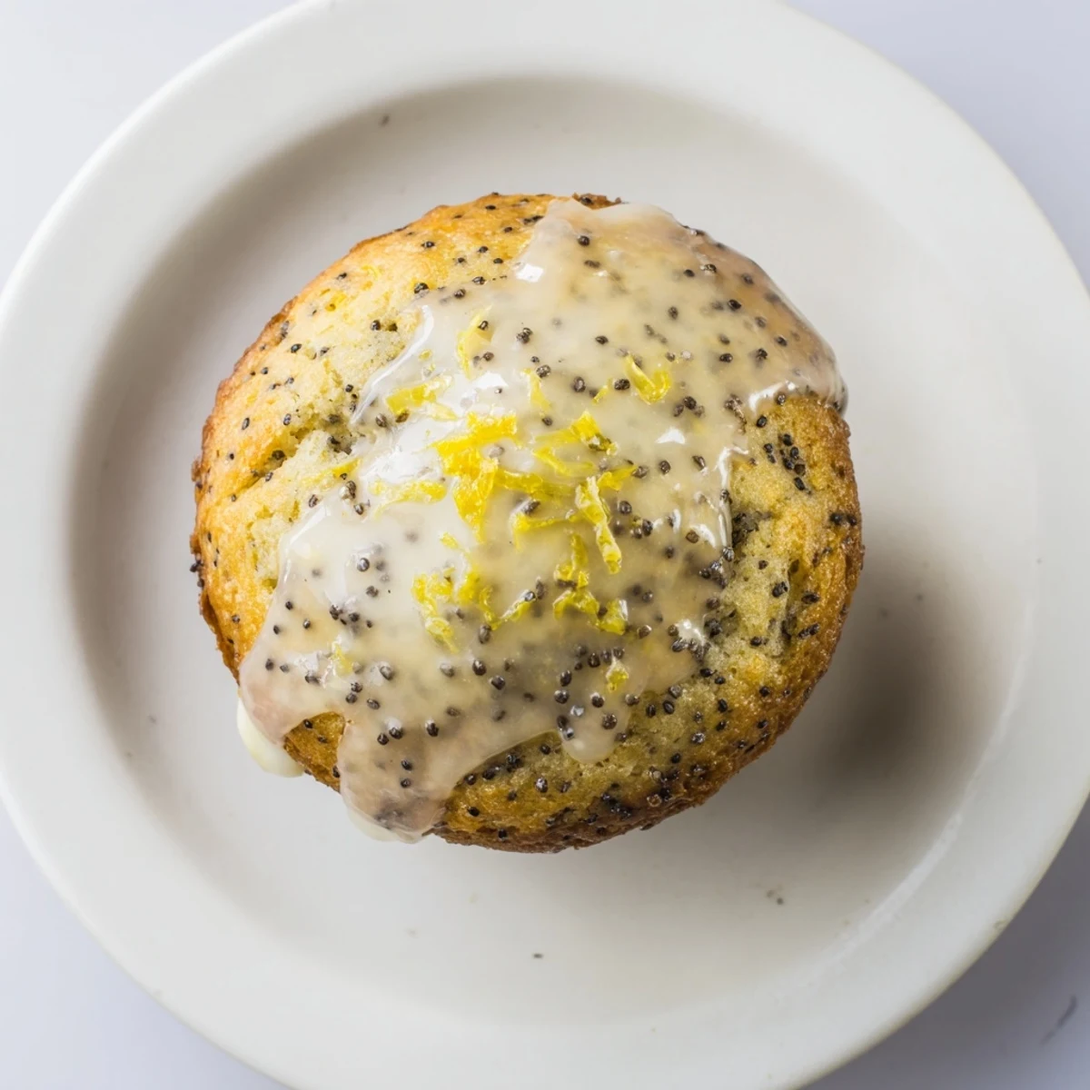 Warm Lemon Poppy Seed Muffins lined in a muffin tin, golden brown and ready to be enjoyed for breakfast.