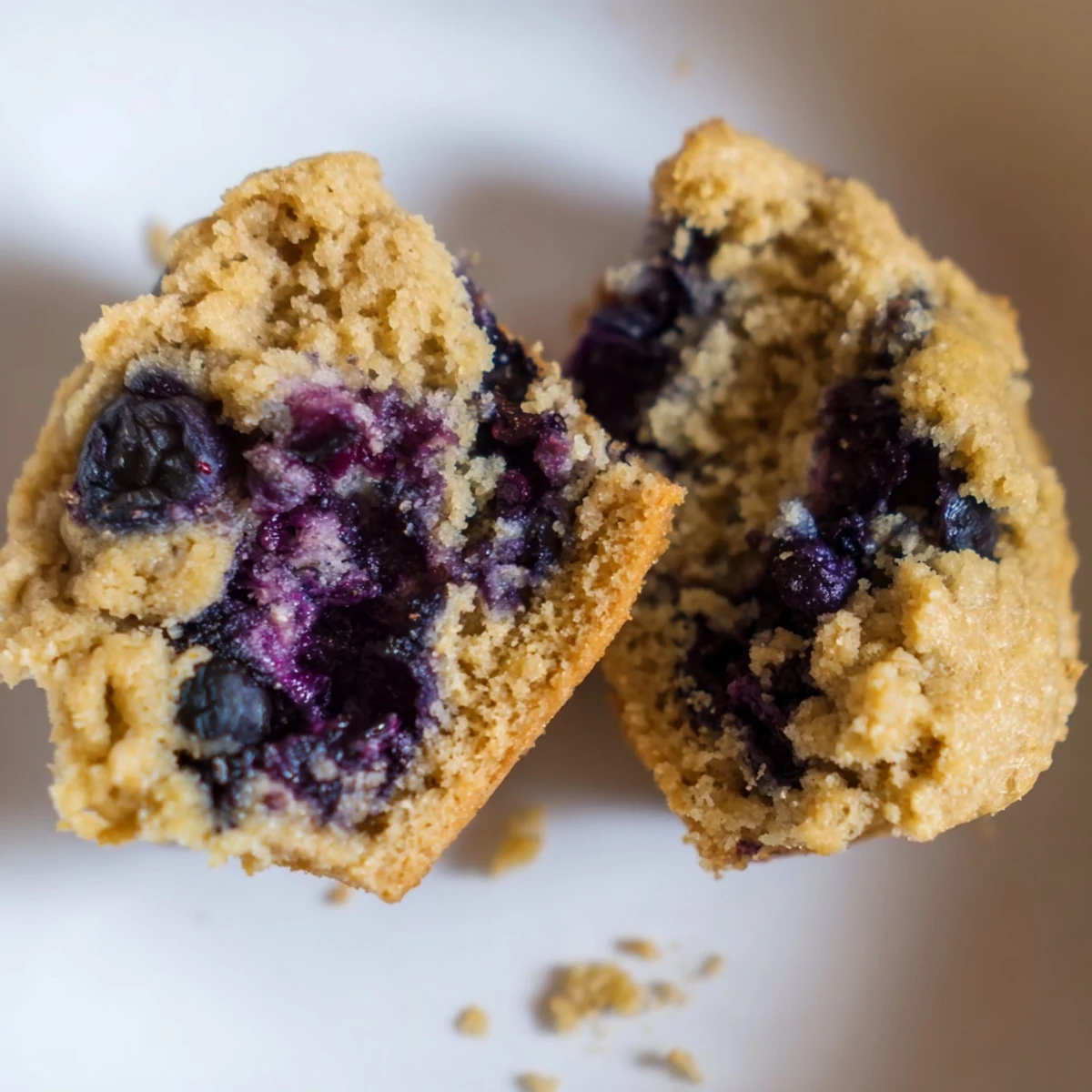 Upright Greek Yogurt Blueberry Protein Muffins in a muffin tin with paper liners, the perfect high protein snack for healthy eating.