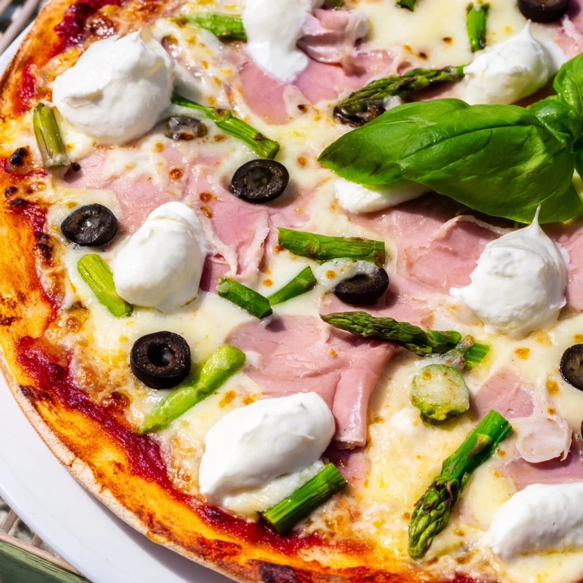 A vibrant slice of Ham, Olive, Asparagus, and Ricotta Pizza on a wooden board, showing melted mozzarella and bright green asparagus spears.