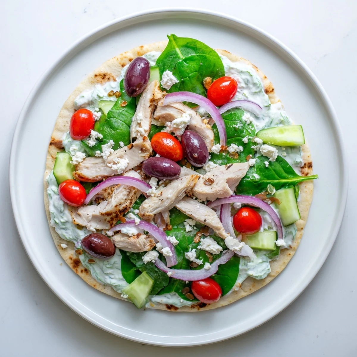 Mediterranean style flatbread loaded with marinated chicken, feta cheese, and crisp garden toppings