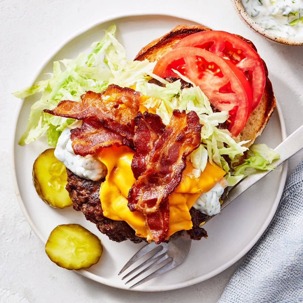 Juicy crack burgers stacked with crispy bacon, melted cheddar, and tangy ranch-mayo sauce on toasted brioche buns