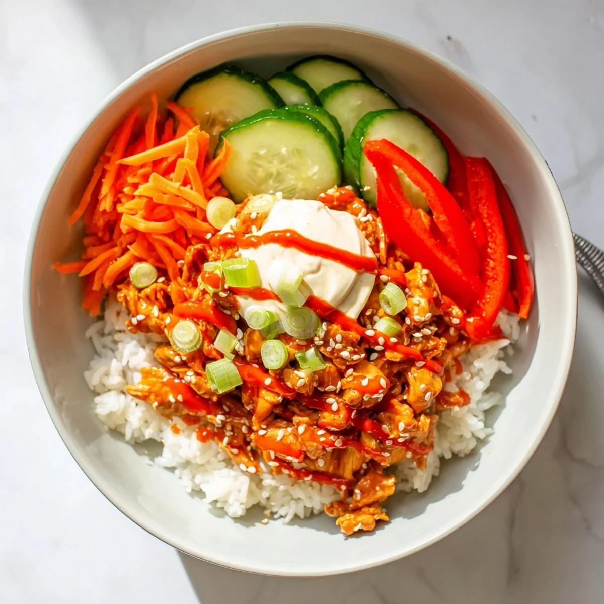 Spicy firecracker ground chicken bowl served over fluffy jasmine rice with crisp vegetables and creamy sriracha drizzle