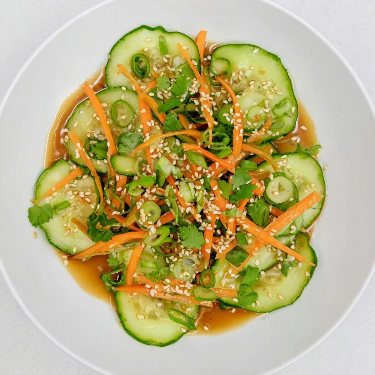 Fresh crisp Asian cucumber salad with thinly sliced cucumbers in tangy sesame soy dressing