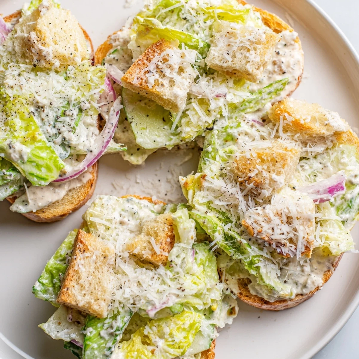 Crisp cucumber Caesar salad with golden croutons and creamy homemade dressing in white bowl