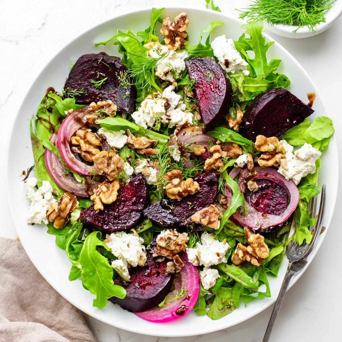 Sliced roasted beets atop mixed greens with crumbled goat cheese and toasted walnuts in this Ultimate Beet Salad