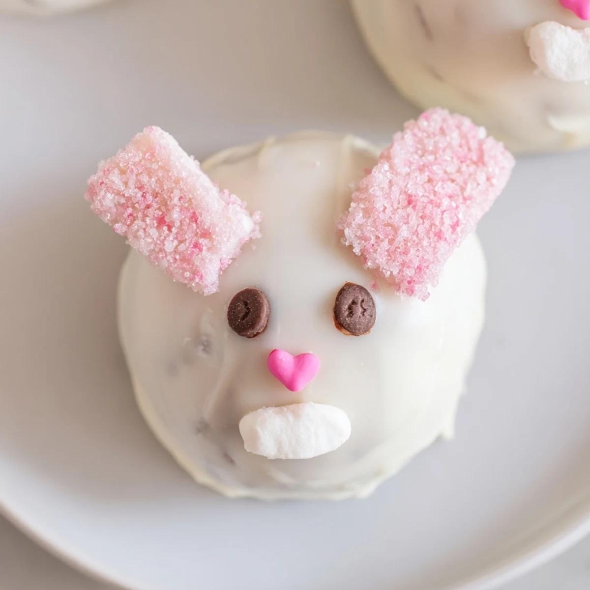 White chocolate coated Bunny Oreo Balls decorated with mini marshmallow ears, chocolate chip eyes, and fluffy tails
