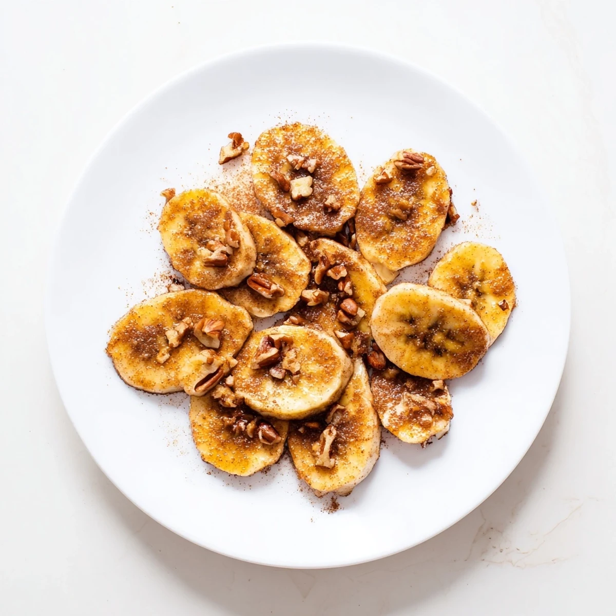 Close-up of pan fried cinnamon bananas showing golden brown surfaces with melted cinnamon sugar coating and soft texture