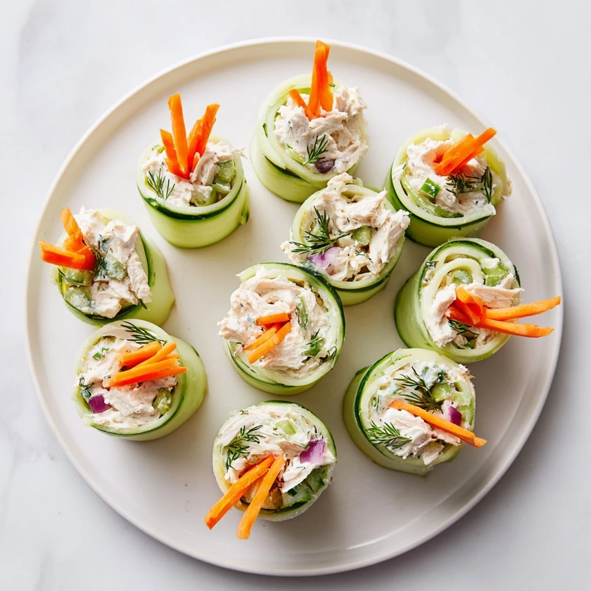 Fresh cucumber ribbons wrapped around creamy chicken salad for a light appetizer.