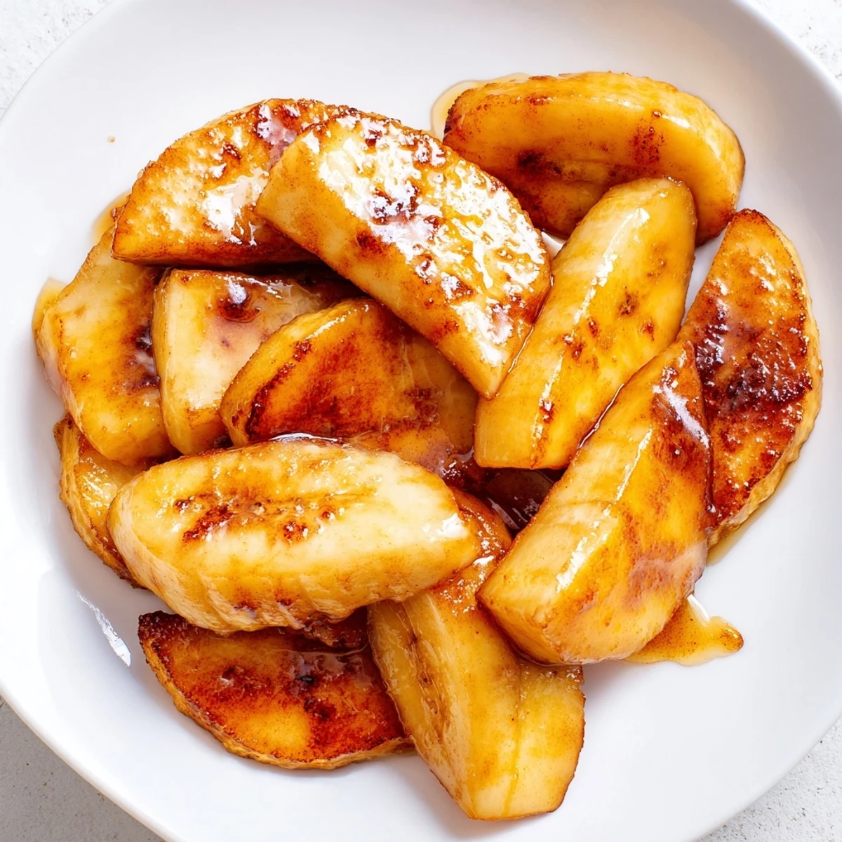 Sweet caramelized pan fried cinnamon bananas in skillet with melted butter coating