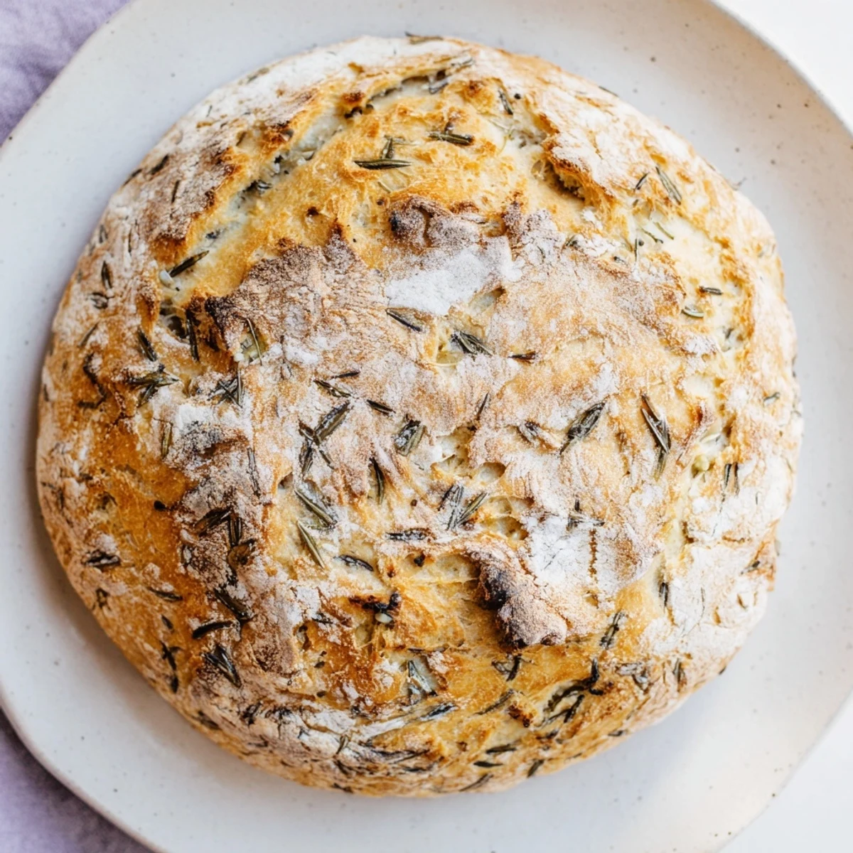 Golden-crusted Dutch oven garlic rosemary bread sliced to reveal soft aromatic interior
