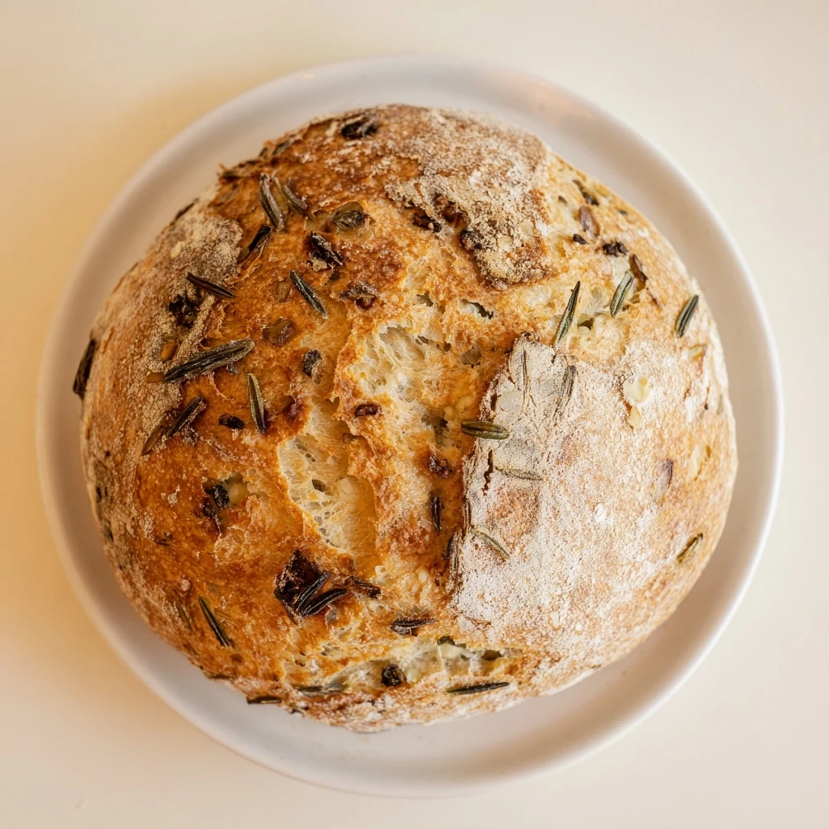 Rustic round loaf with crispy golden exterior studded with fragrant garlic rosemary bits
