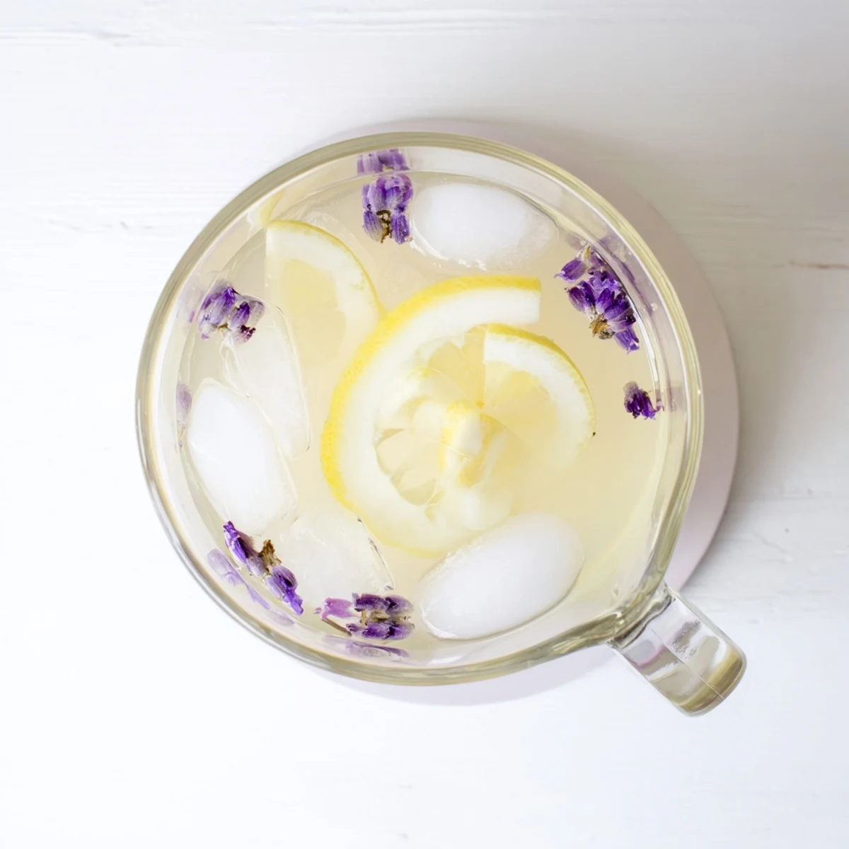 Refreshing lavender lemonade served in a mason jar with floating ice cubes and citrus wheel garnish
