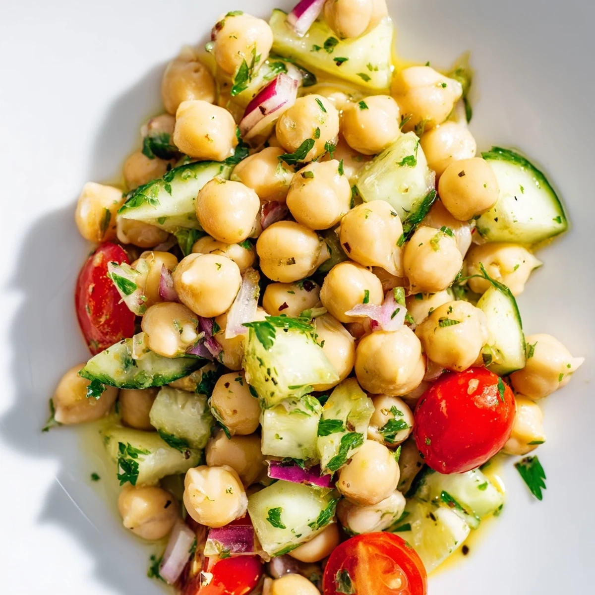 Colorful Mediterranean chickpea cucumber salad featuring ripe tomatoes and crisp vegetables tossed with parsley