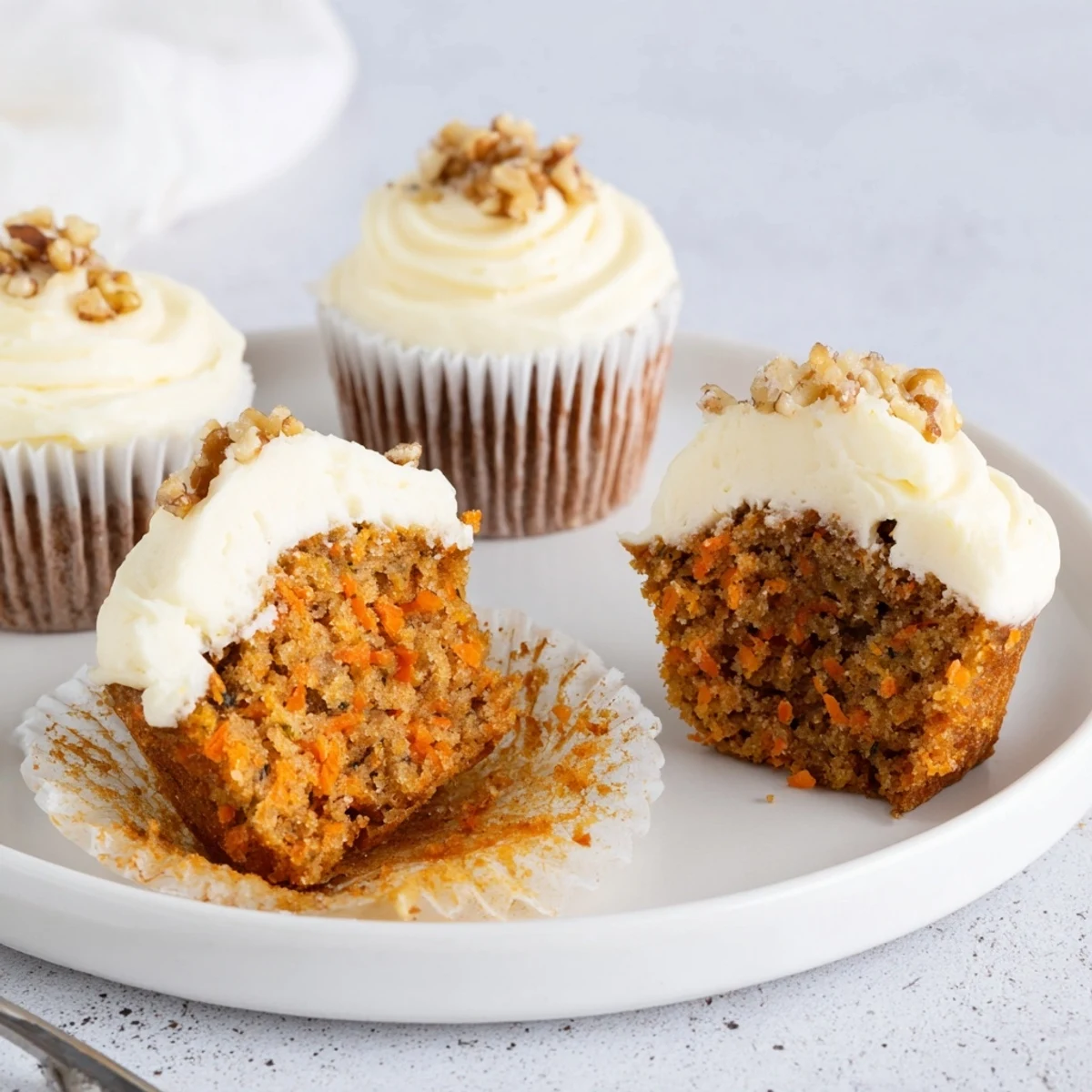 Moist Carrot Cake Cupcakes topped with creamy frosting and toasted pecans
