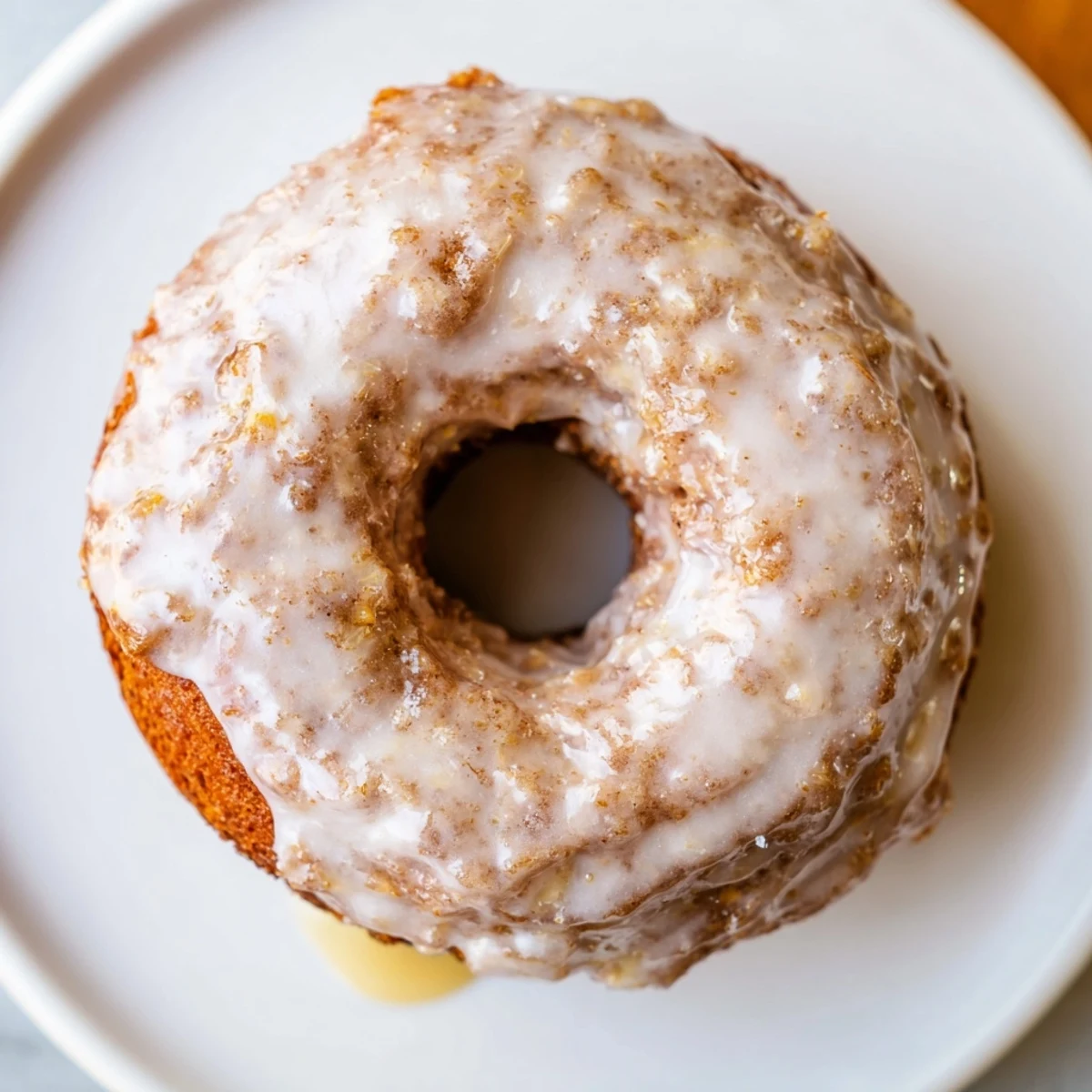 Plate of Banana Donuts drizzled with vanilla glaze, soft cake-like crumb.