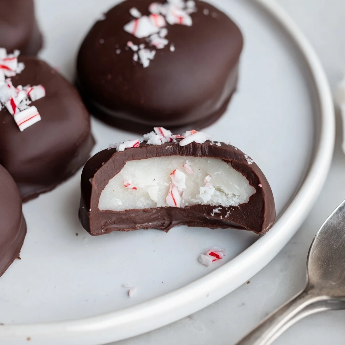Homemade Peppermint Patties arranged on parchment, sprinkled with crushed candy
