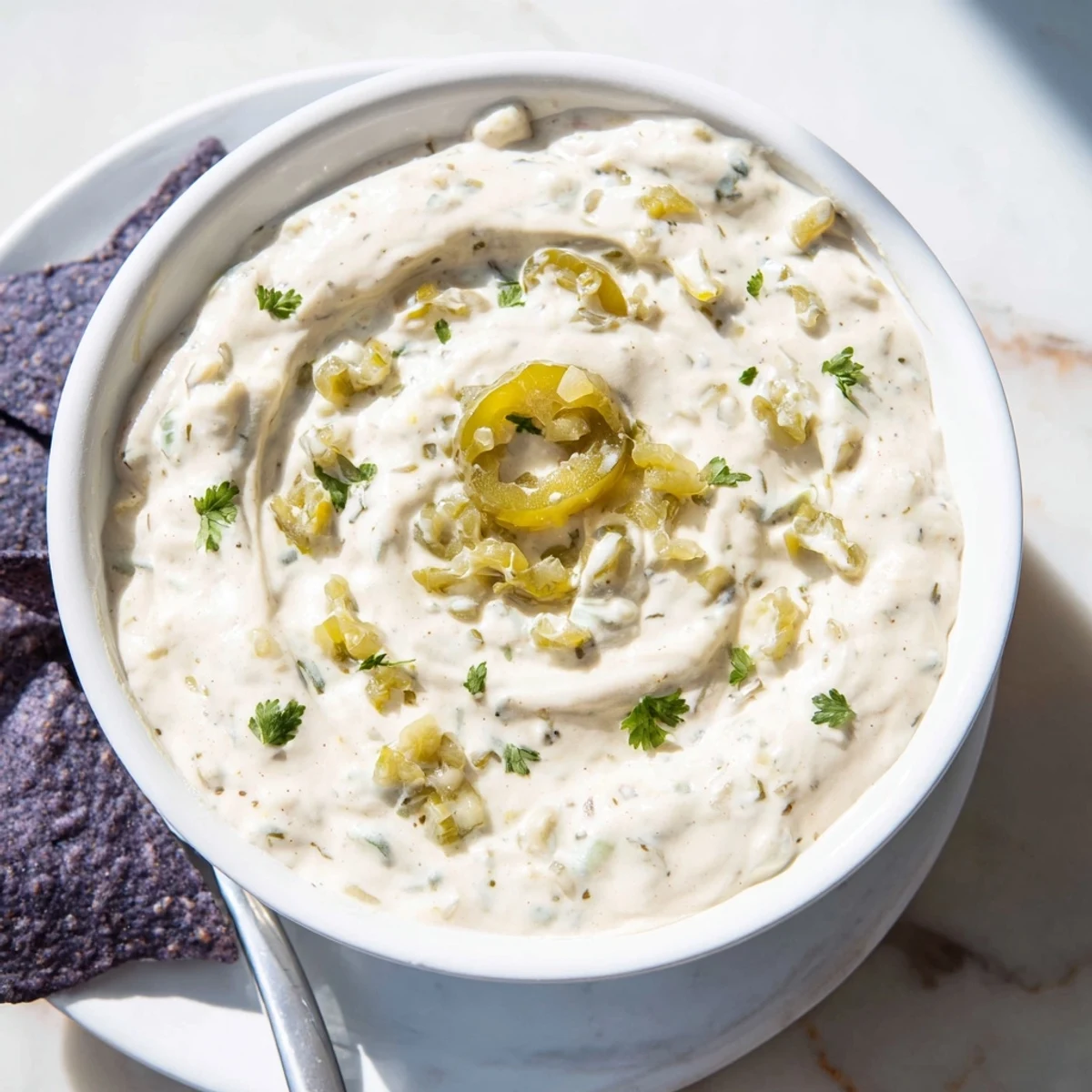 Small bowl of tangy Mexican white sauce recipe served beside golden tortilla chips