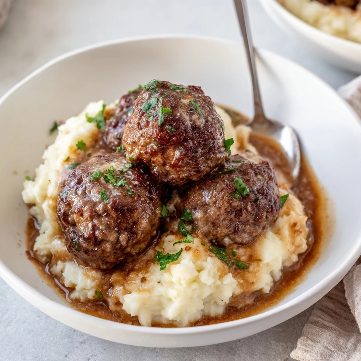 Crockpot Meatballs Gravy bubbling over mashed potatoes, rich brown sauce glistening