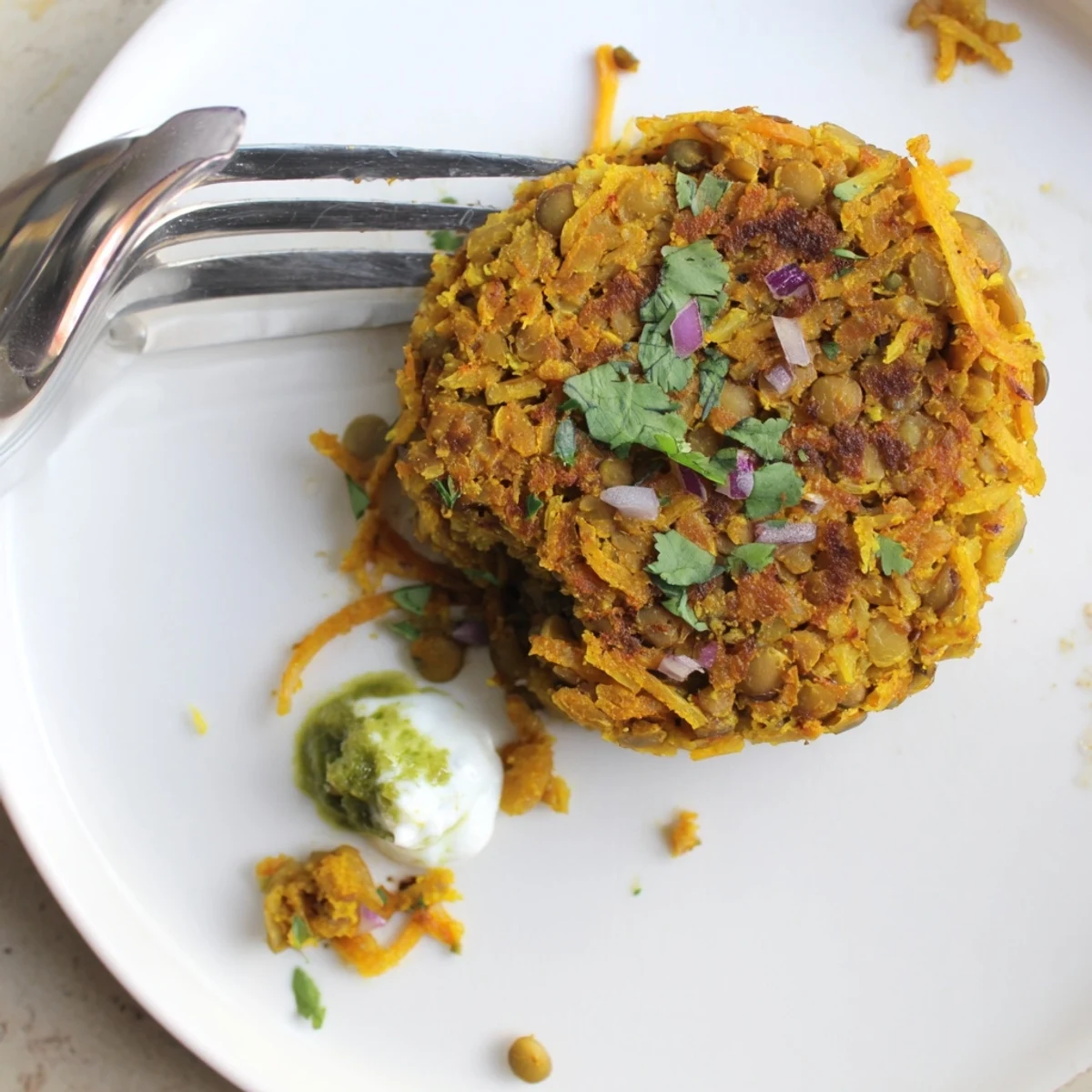 Warm Crispy Sweet Potato Lentil Patties stacked on plate with avocado dip.