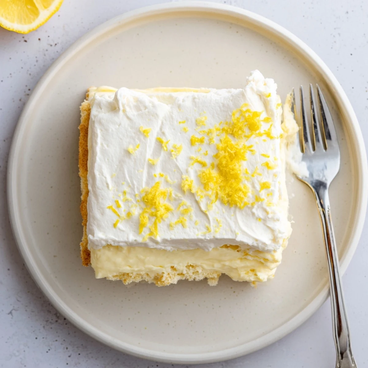 Lemon Lush Cake with crisp cookie crust, creamy lemon layer, fluffy topping