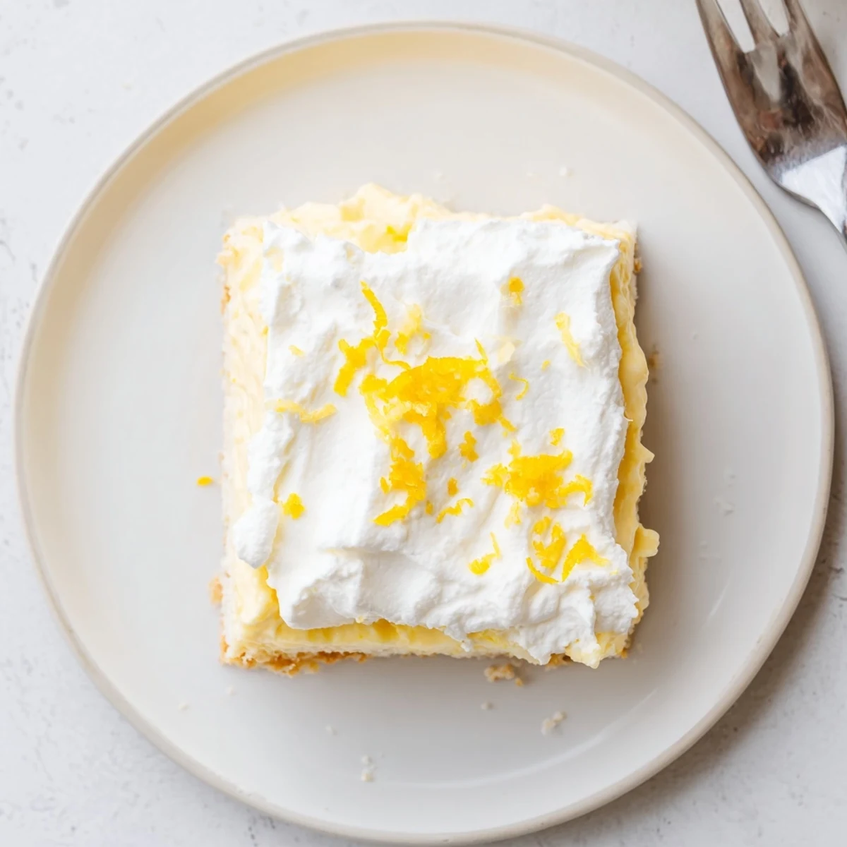 Sliced Lemon Lush Cake chilled overnight, zesty filling and cloudlike whipped topping