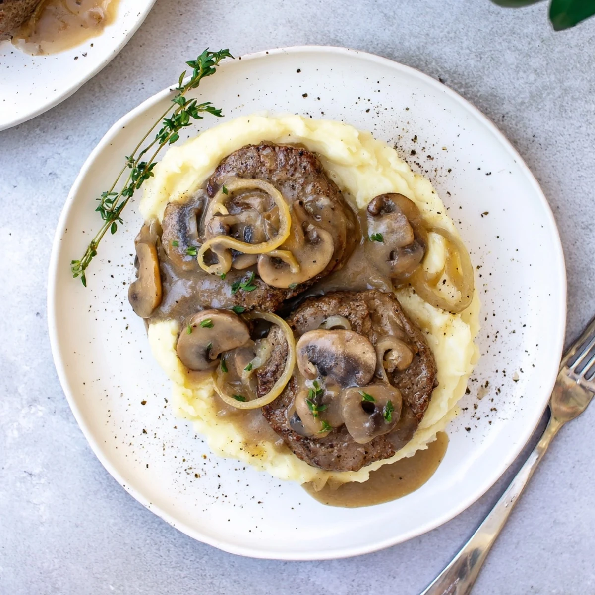 Slow-simmered Country Style Smothered Cube Steak Recipe, tender meat nestled in skillet
