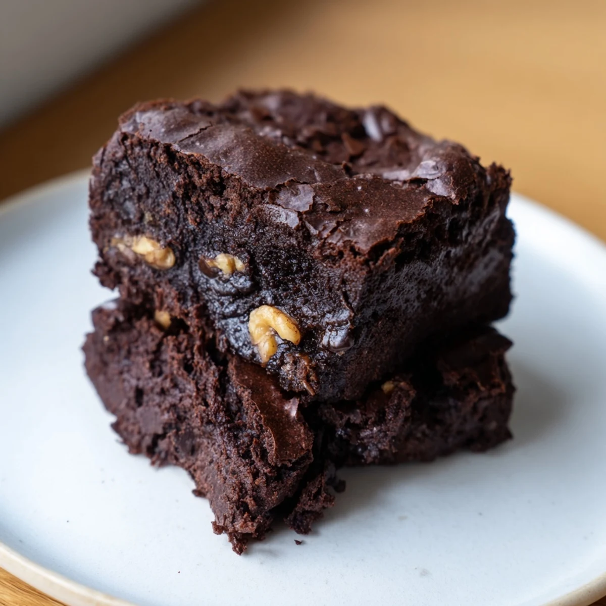 Warm ultimate brownies served on a rustic plate beside vanilla ice cream scoops