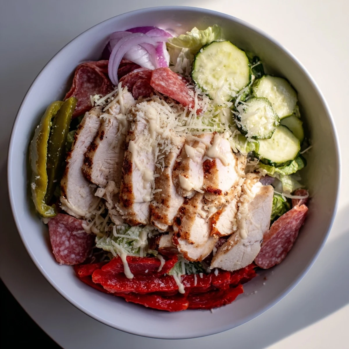 Tender grilled chicken tops this hearty Italian Grinder Chicken Salad with ham, cheese, and tangy pepperoncini peppers.  