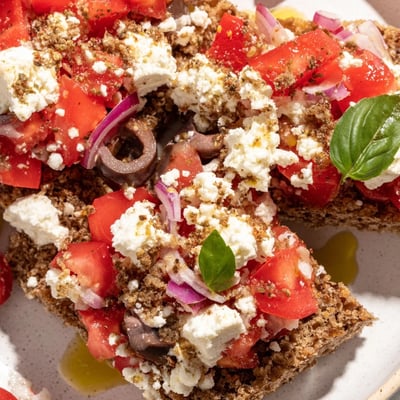 Crunchy whole grain Cretan feta rusks drizzled with olive oil on rustic plate