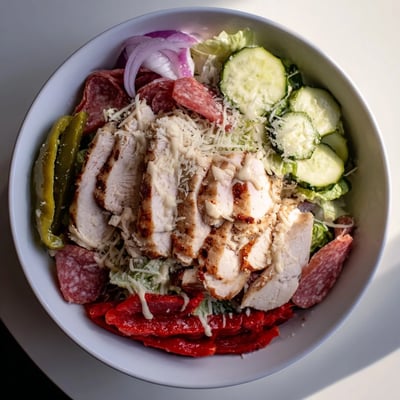 Tender grilled chicken tops this hearty Italian Grinder Chicken Salad with ham, cheese, and tangy pepperoncini peppers.  